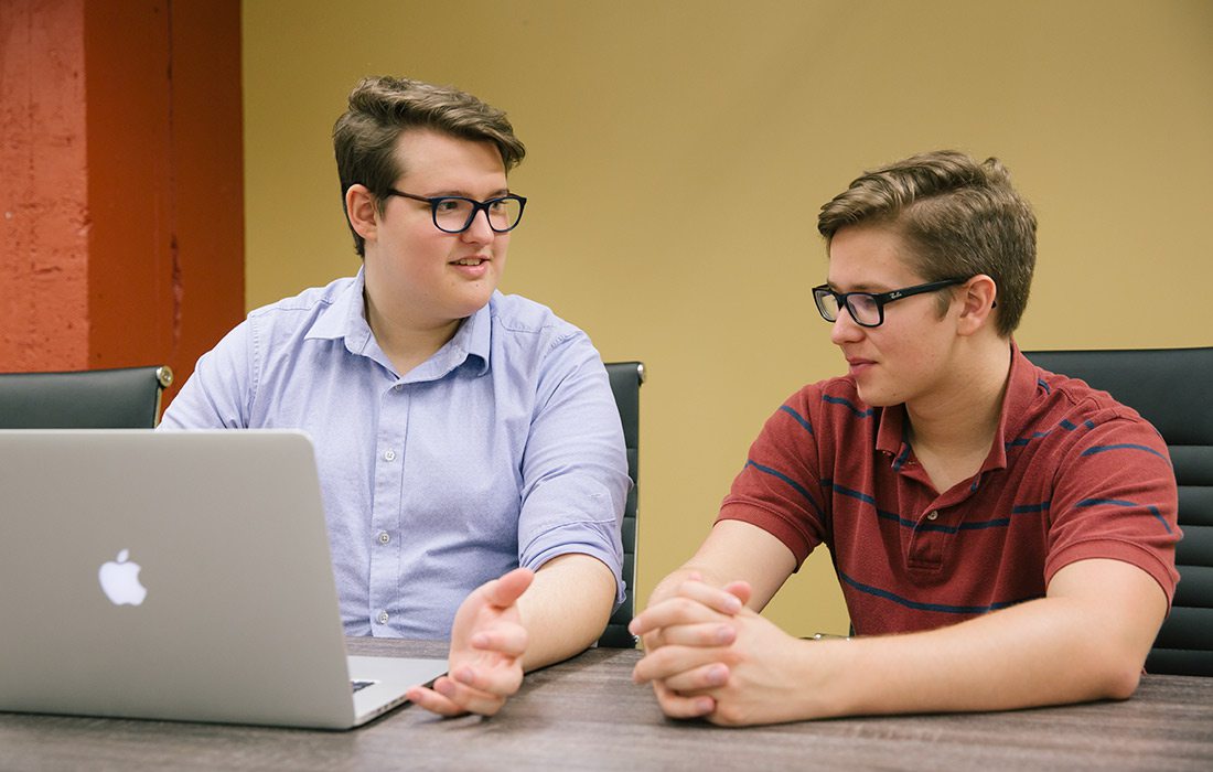 Taylor Flores and Brenden Reeves working at a laptop