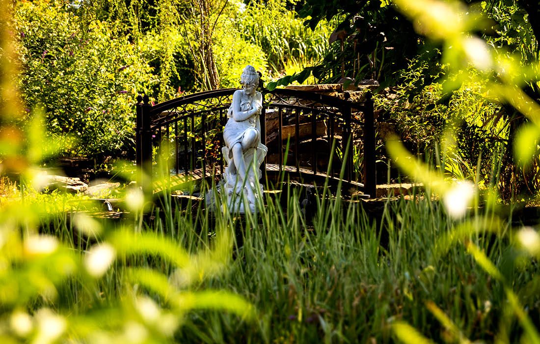 Bridge and statue in Victorian-themed southwest Missouri garden