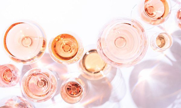 Rosé wine in glasses on a white surface