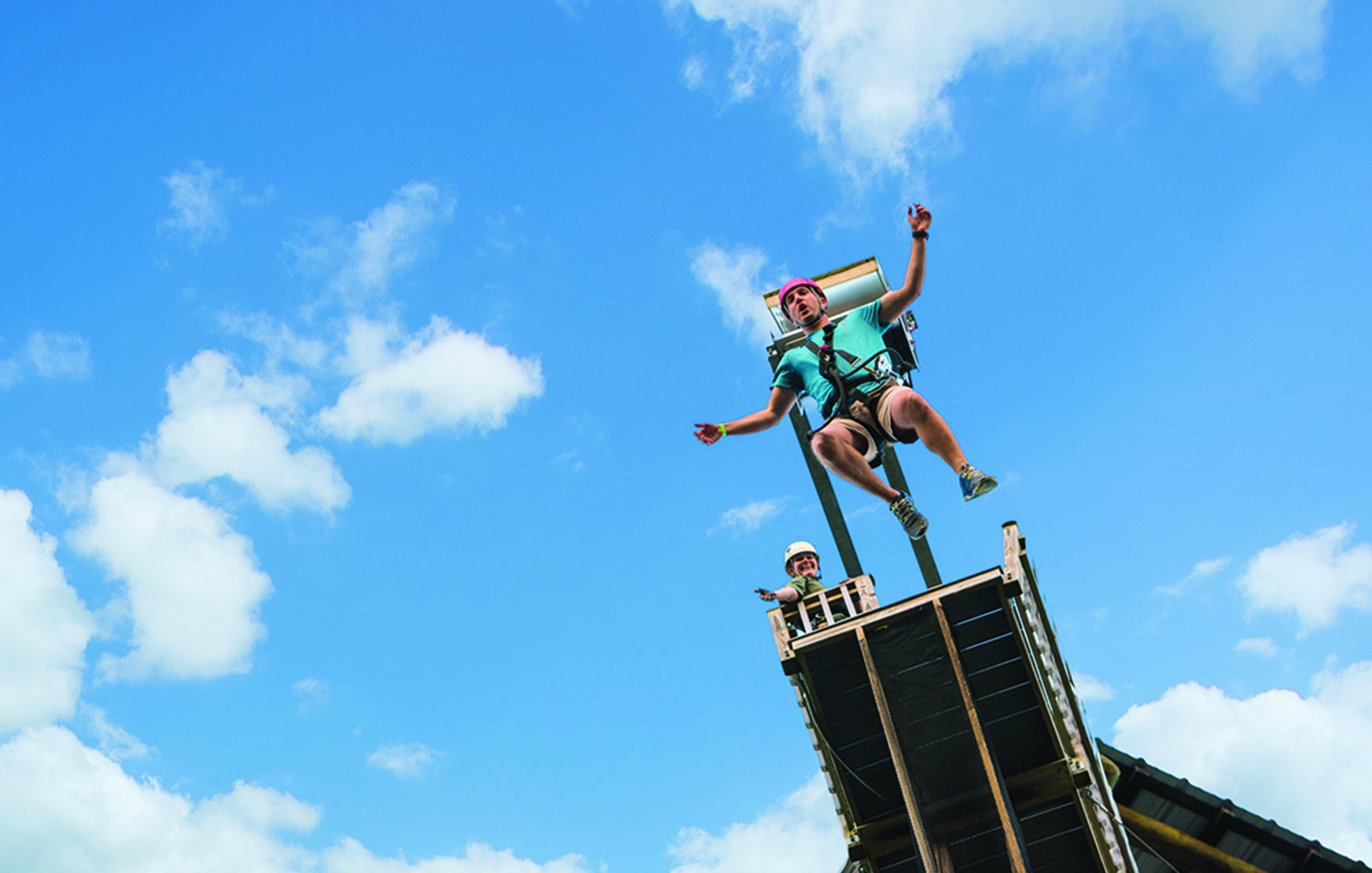 A man jumps off a ledge in bungee gear.