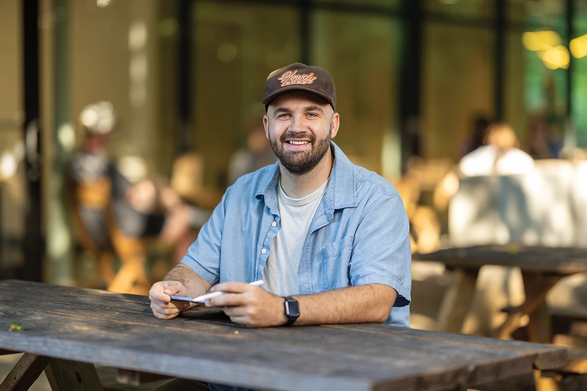 Camp Ape founder Andrew Lovell at an outdoor coffee-shop table.