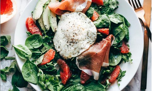 breakfast salad with prosciutto and a fried egg