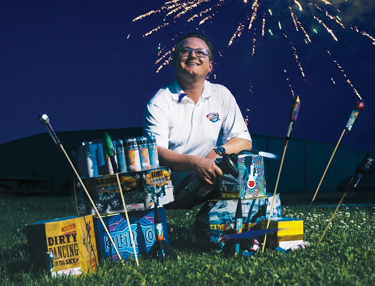 Michael Ingram stands in front of a fireworks display