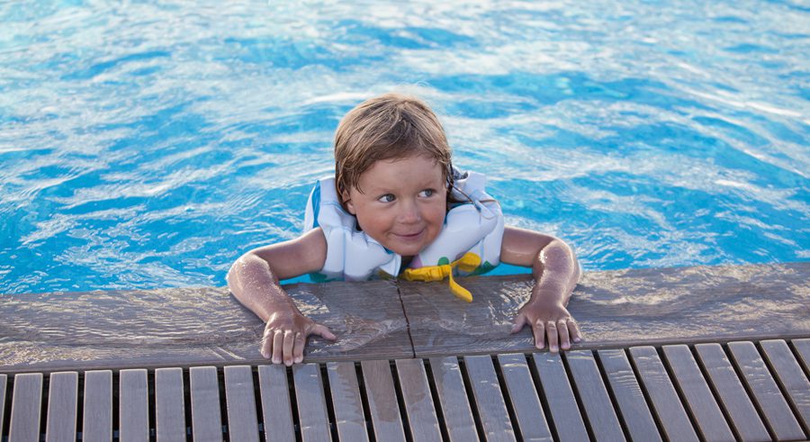 Kid in pool wearing lifejacket