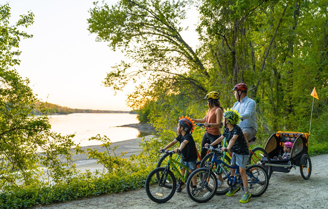 Family of five on bikes stop to look at lake