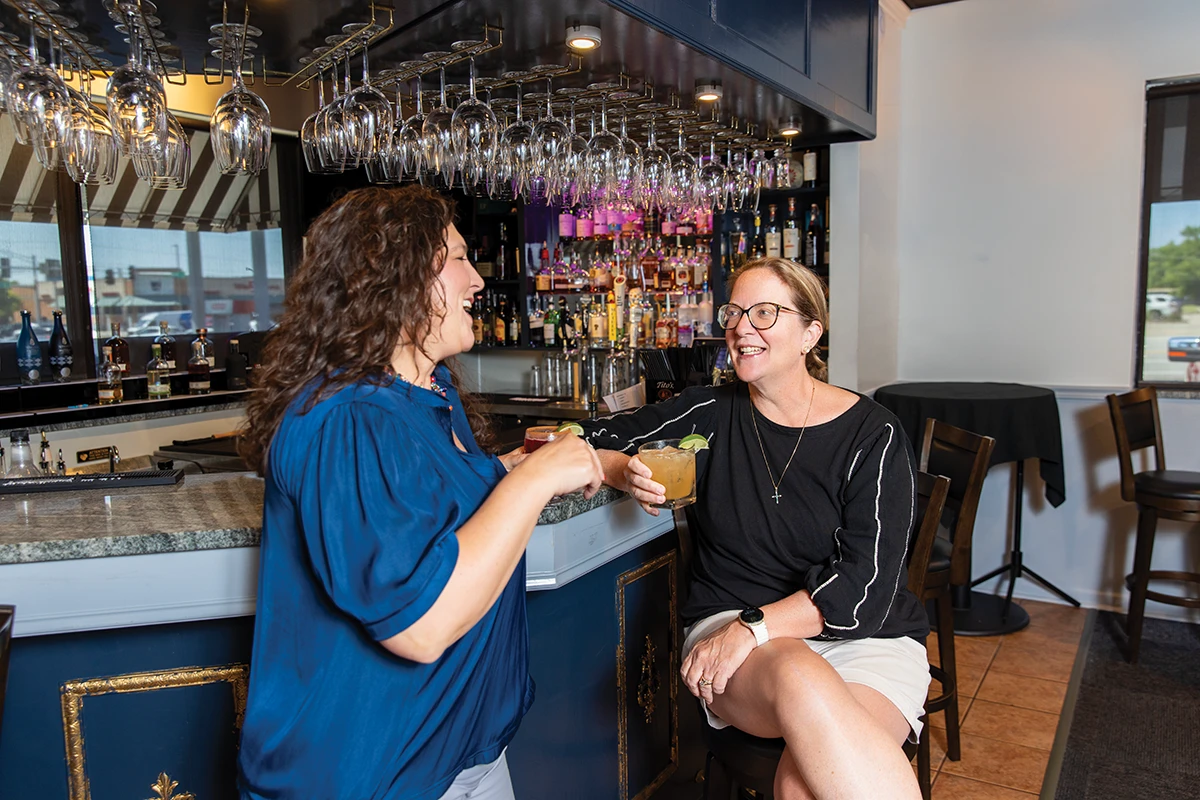 Simply Delicious Catering owner Patty Wingo and Biz 417 editor Dori Grinder at a bar.