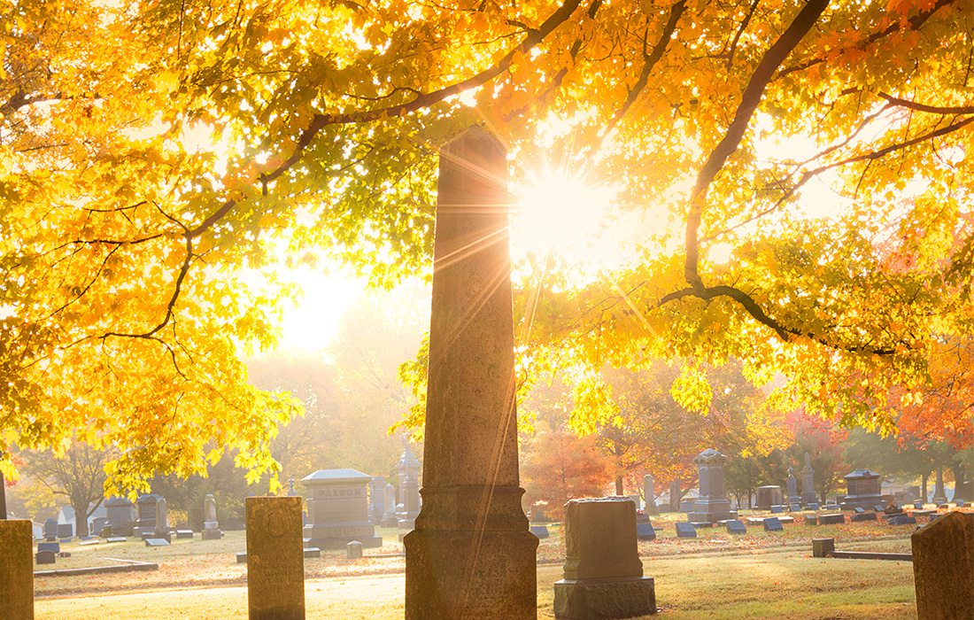 tombstone and sun shining in cemetery