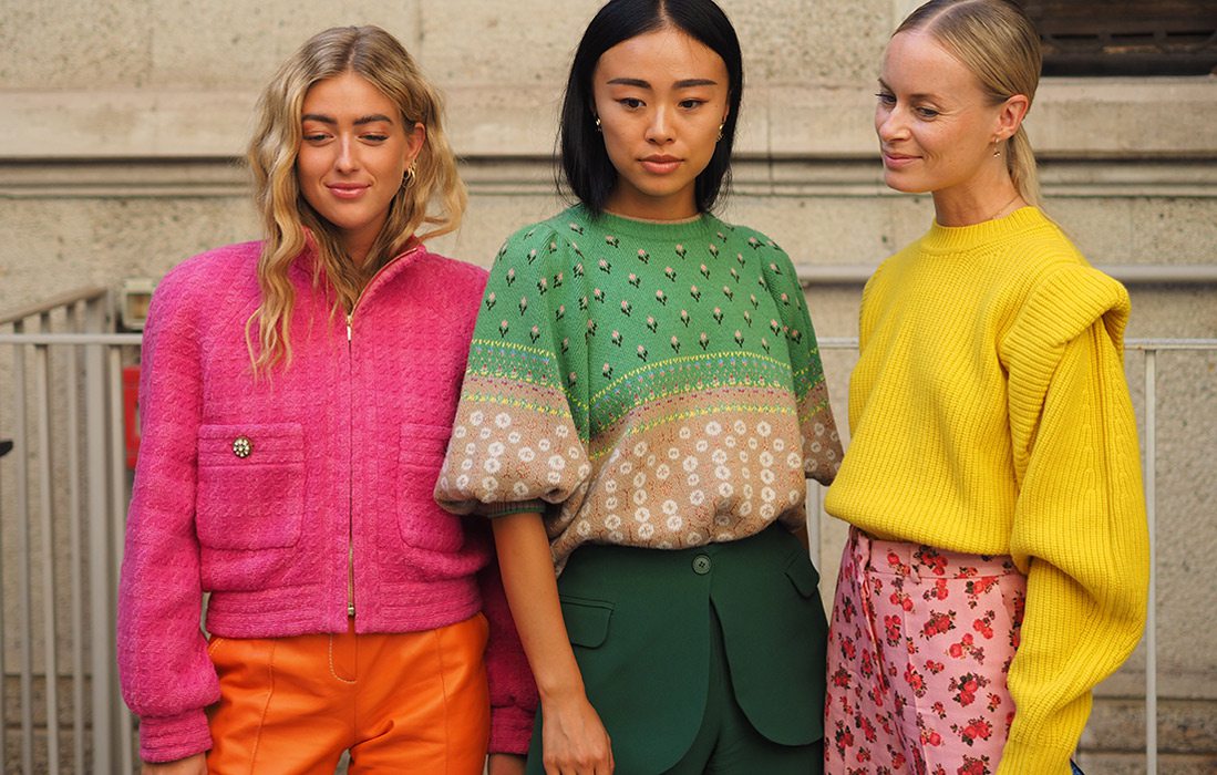 Three girls wearing bright colored outfits