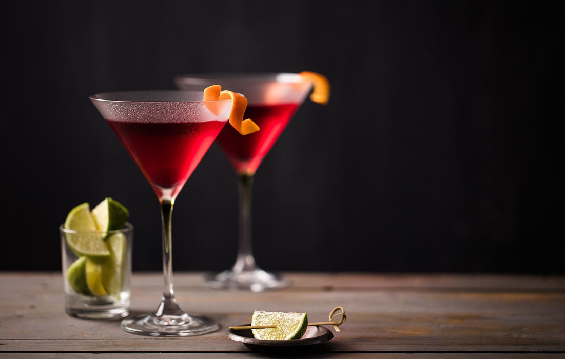 Two cosmopolitans sit next to limes