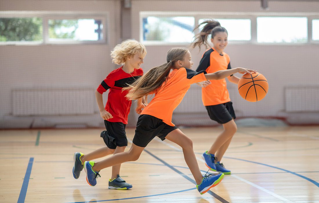 Stock photo of kids playing basketball indoors