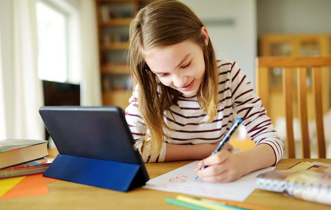 Stock image of young girl taking an online class