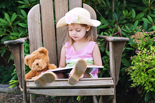 Stock photo of little girl reading outside
