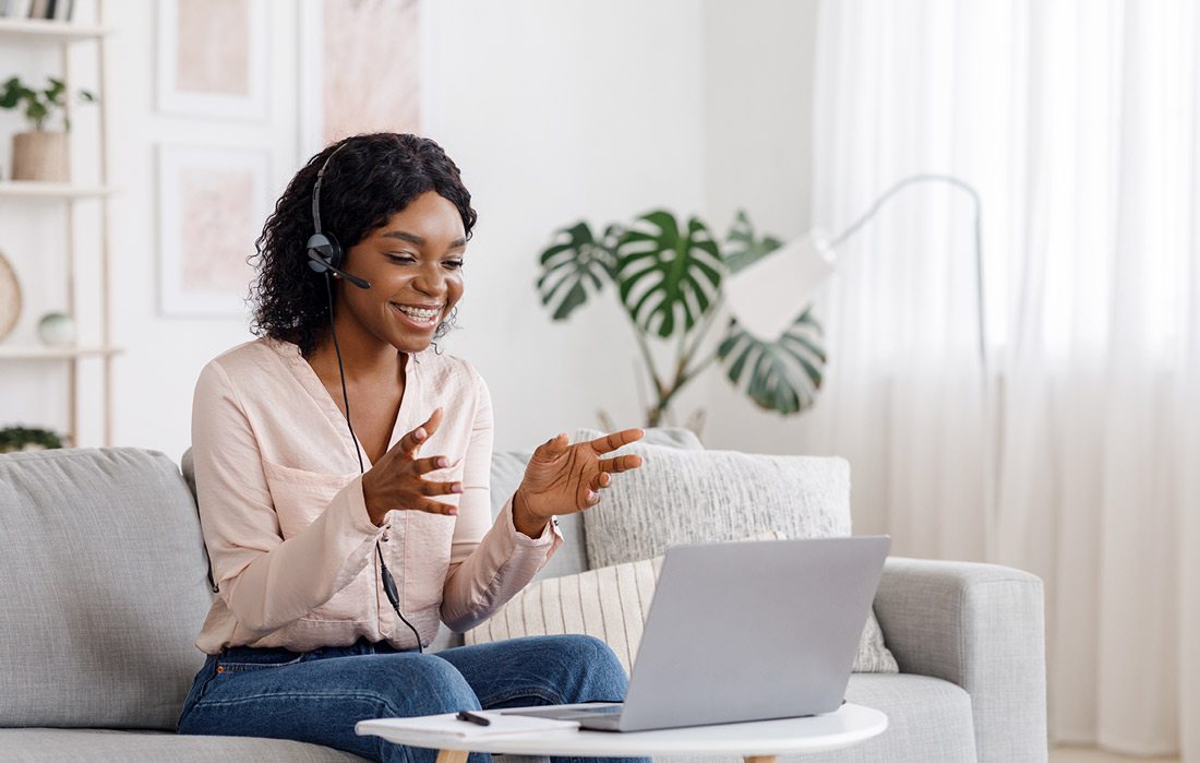 Woman talking on headset with laptop