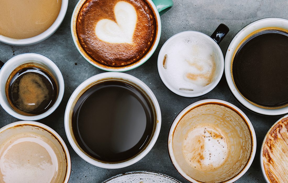 A barista pours milk into a cappuccino