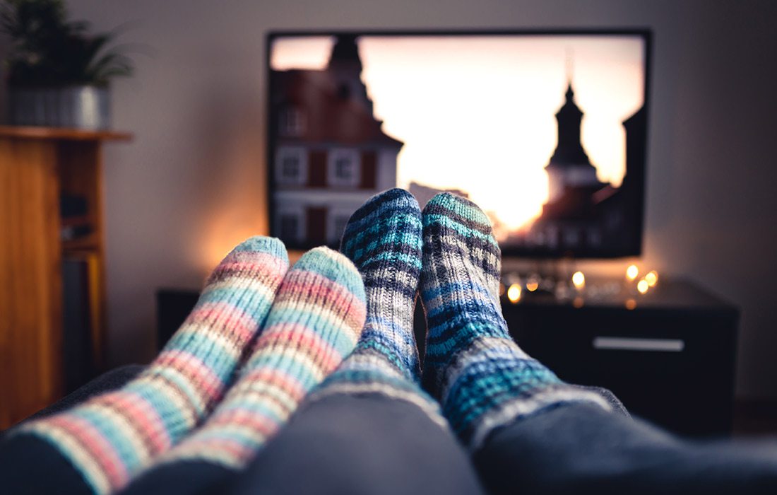 Couple streaming TV together stock photo.